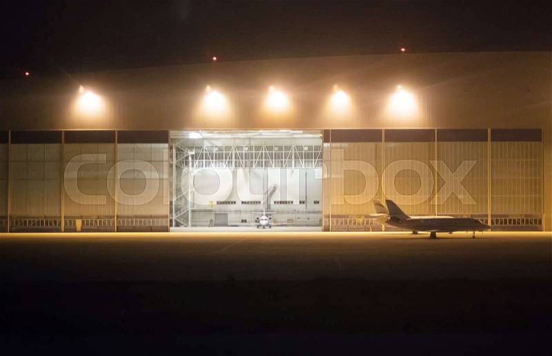 Passenger planes near hangar at night airport, stock photo