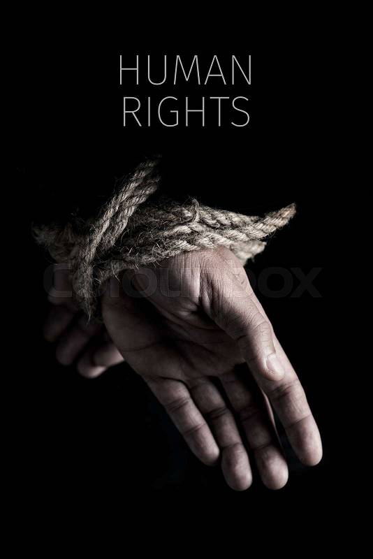 Closeup of a man with his hands tied behind his back with rope, and the text human rights against a black background, stock photo