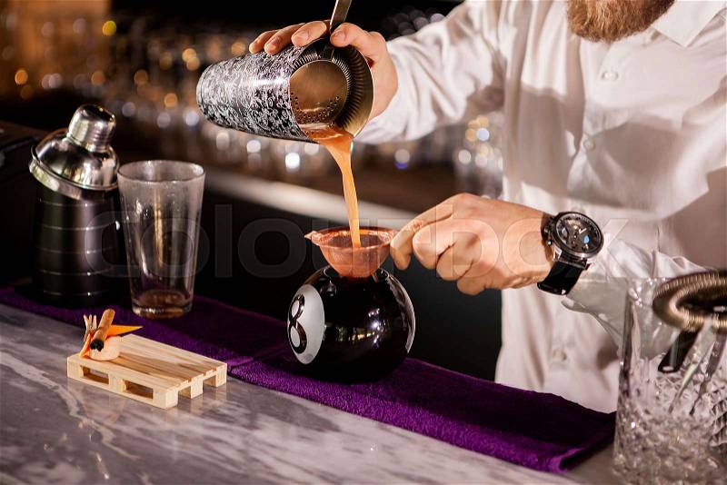 Bartender bartender is pouring a drink. Alcoholic drink, stock photo