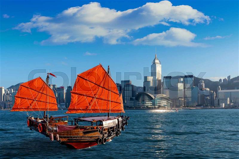 Victoria Harbour with junk ship in Hong Kong, stock photo