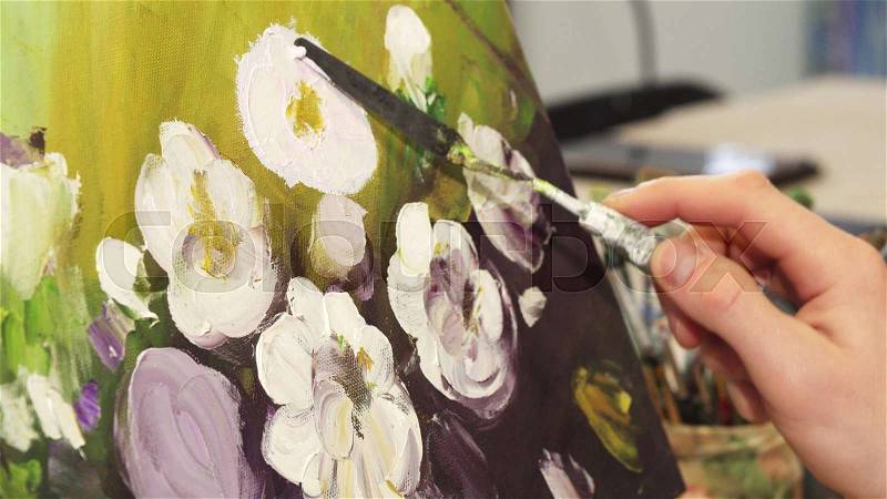 Cropped close up of a professional artist working at his Art Studio finishing his artwork drawing beautiful flowers hobby equipment colorful picture oil paint brush ..., stock photo