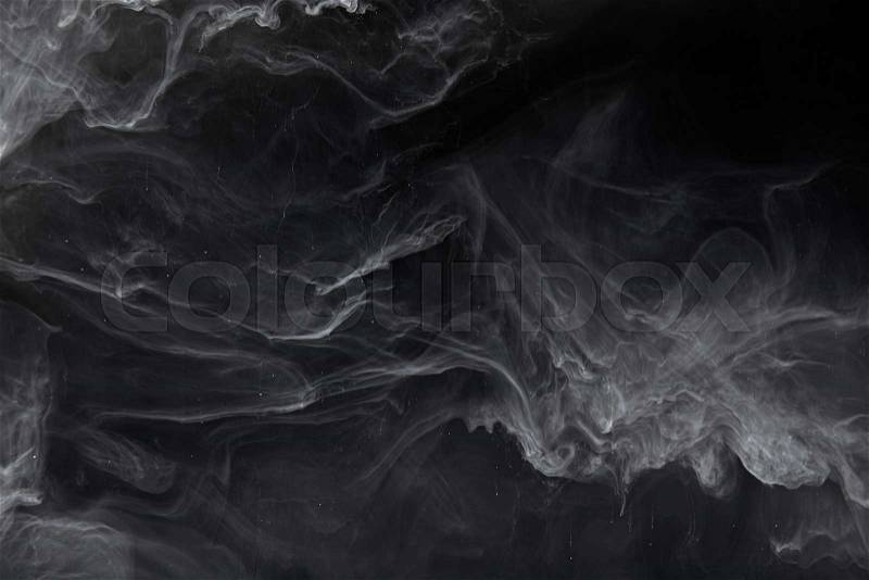 Abstract swirls of grey paint on black background, stock photo
