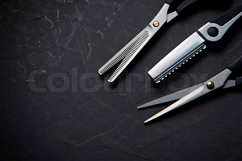Hairdressing tools on black background with copy space at top, stock photo