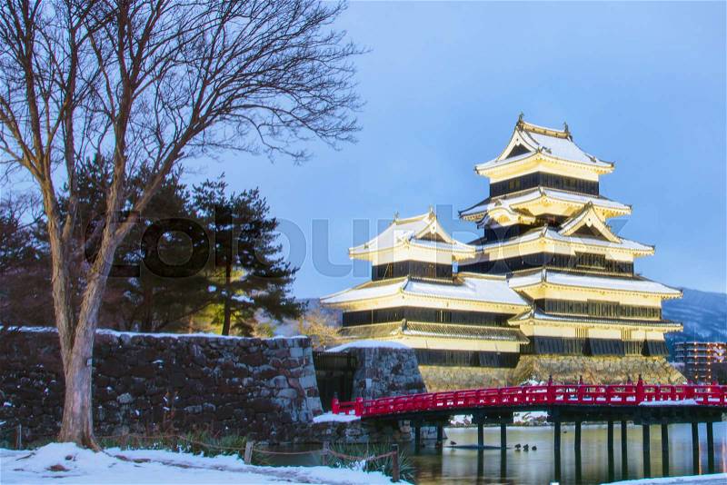 Matsumoto Castle (Crow Castle) in Nagono city, Japan.Castle in Winter with snowfall with light up and twilight time, stock photo