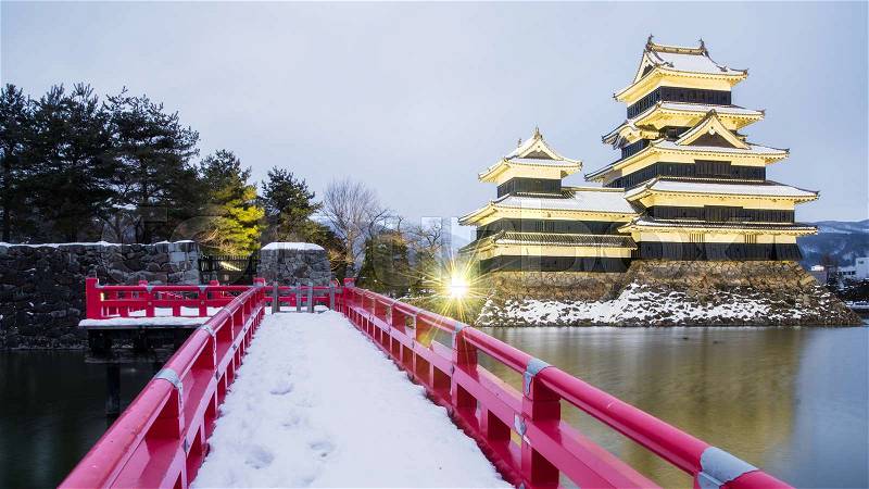 Matsumoto Castle (Crow Castle) in Nagono city, Japan.Castle in Winter with snowfall with light up and twilight time, stock photo