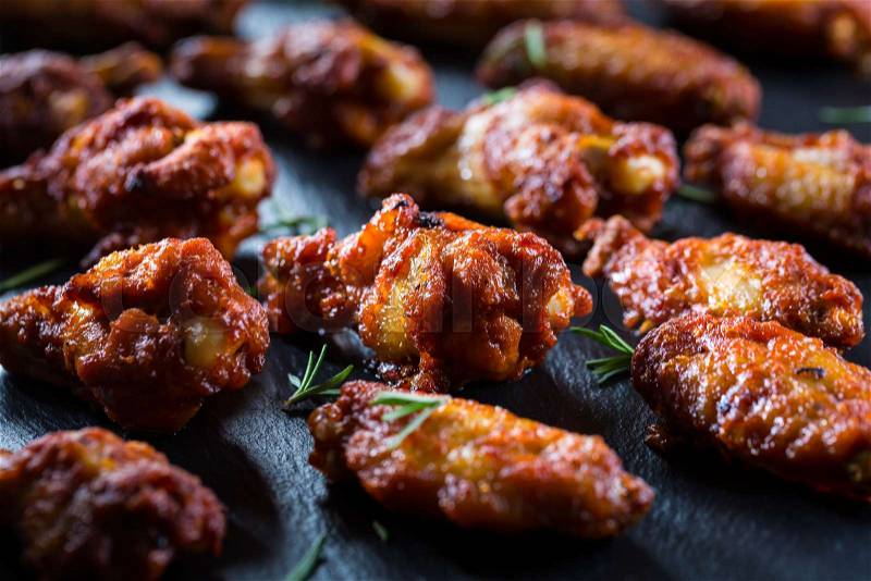 Hot and spicy chicken wings with spices on dark background , stock photo