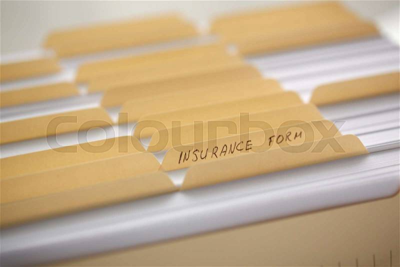 Yellow folders with labels and paper in a row in the insurance file closeup, stock photo