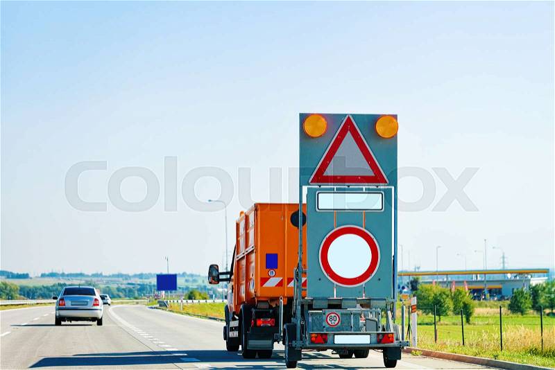 Truck carrying empty triangle and empty circle traffic road sign in highway in Poland, stock photo