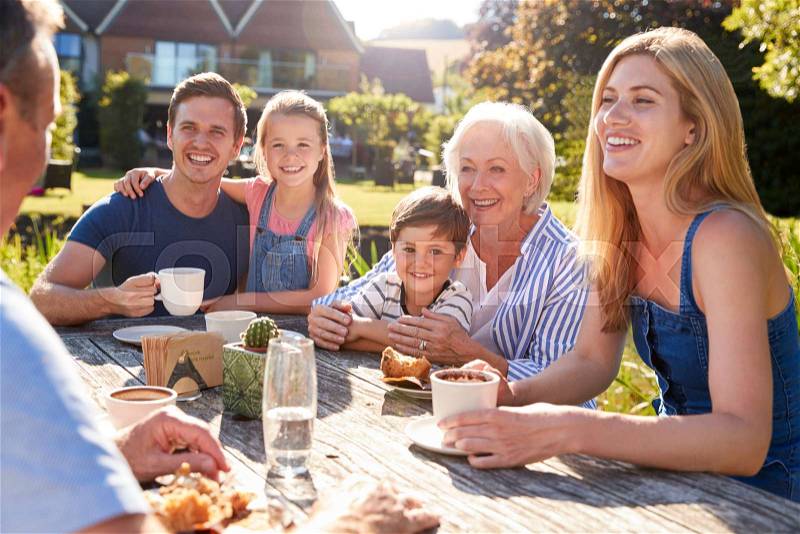 Multi Generation Family Sitting At Table Enjoying Outdoor Summer Drink At Cafe, stock photo