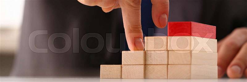 Male hand holds red wood block of stair finish next step rare progress personnel talent authority hot pyramid background on ladder different insurance concept ..., stock photo