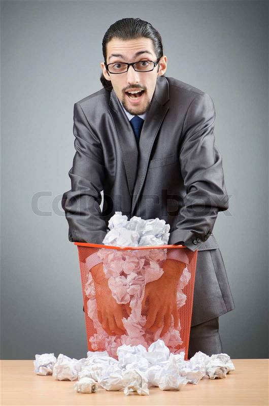 Man with lots of wasted paper, stock photo