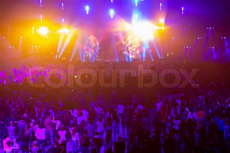 Concert crowd having fun at a rock concert. Large concert hall with a big stage. A lot of people. Lightning equipment. Television shooting a concert on several ..., stock photo