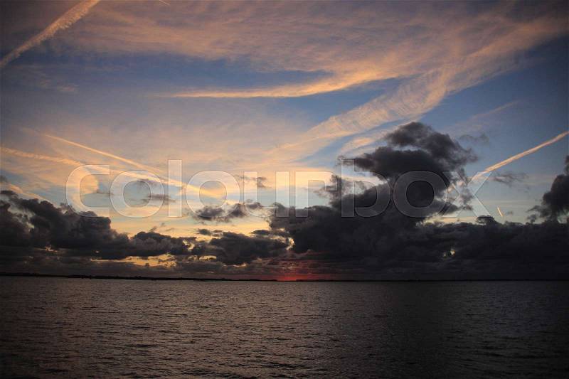 The river and in the distance the beautiful sunset with grey clouds in the autumn, stock photo