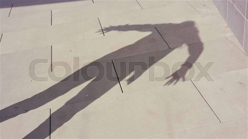 A young woman\'s shadow dancing outside. Medium shot, stock photo