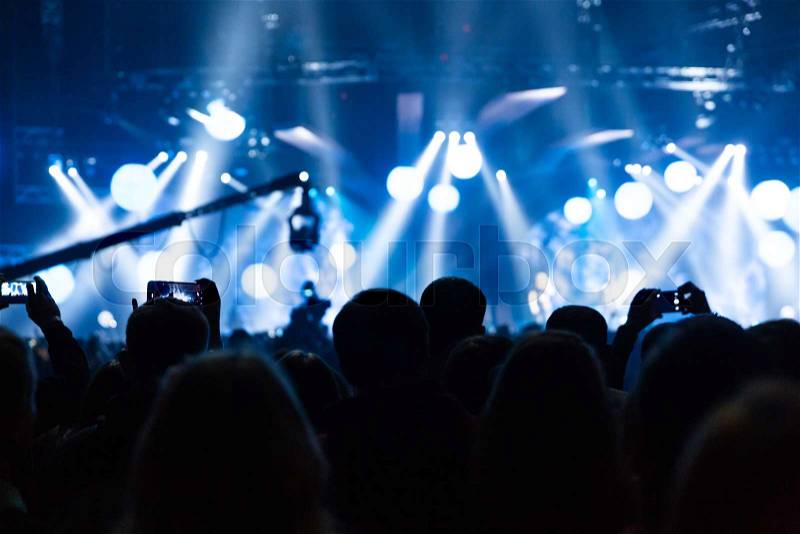 Silhouette of a concert crowd. The audience looks towards the stage. Party people at a rock concert. Musical party. Musical show. Group silhouette. Young audience, stock photo