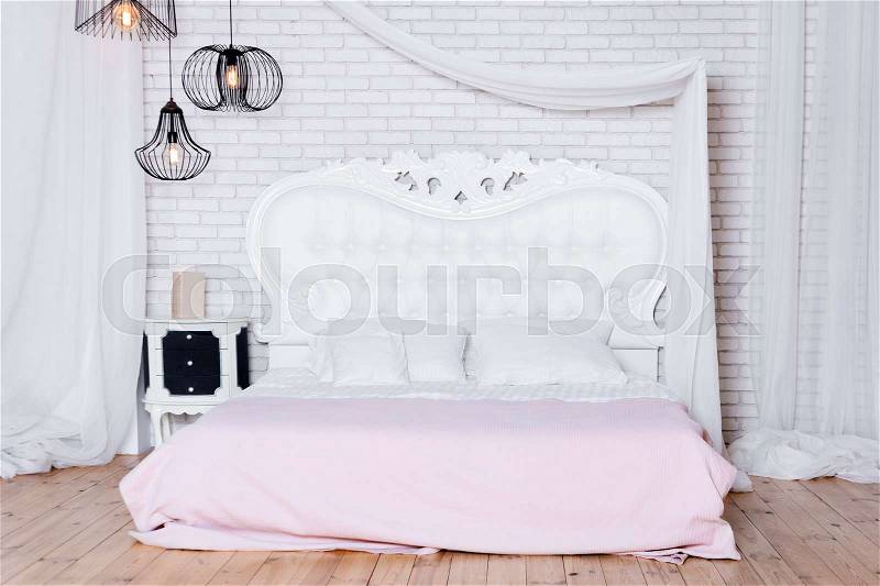 King size bed in loft apartment. Loft style bedroom with white design, stock photo