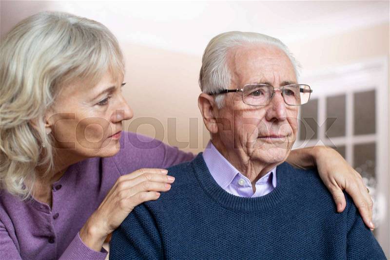 Confused Senior Man Suffering With Depression And Dementia Being Comforted By Wife, stock photo