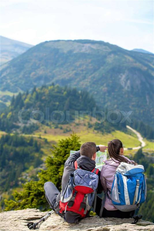 Smiling adventure couple with map on slope. look at map, stock photo