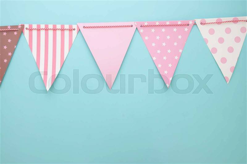 Pastel colour bunting or party flags on blue background. Party or anniversary background, stock photo