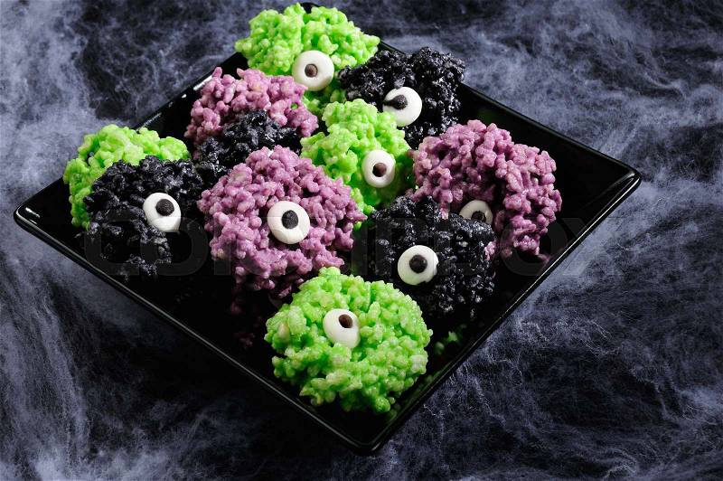 Monsters eye balls- made from marshmallows Rice krispies bites crispy bite balls. These are delicious, delight have a creepy monster and funny colors of Halloween, stock photo
