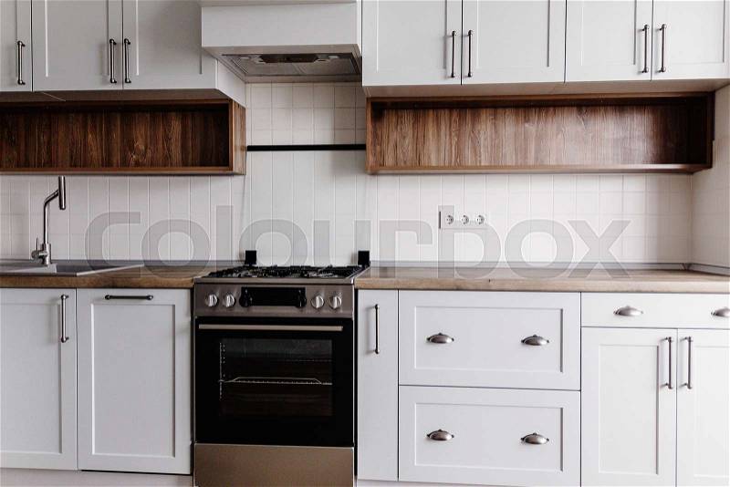 Luxury modern kitchen furniture in grey color and steel oven, sink, wooden tabletop and floor. Gray cabinets in scandinavian style. Home renovation. Stylish kitchen ..., stock photo