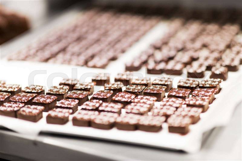 Sweets production and industry concept - chocolate candies at confectionery shop, stock photo