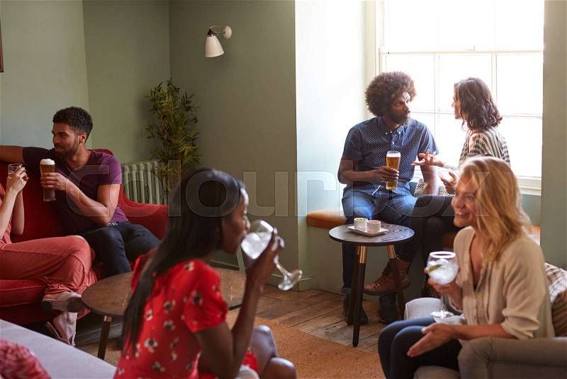 A group of people in a pub drinking and talking, stock photo