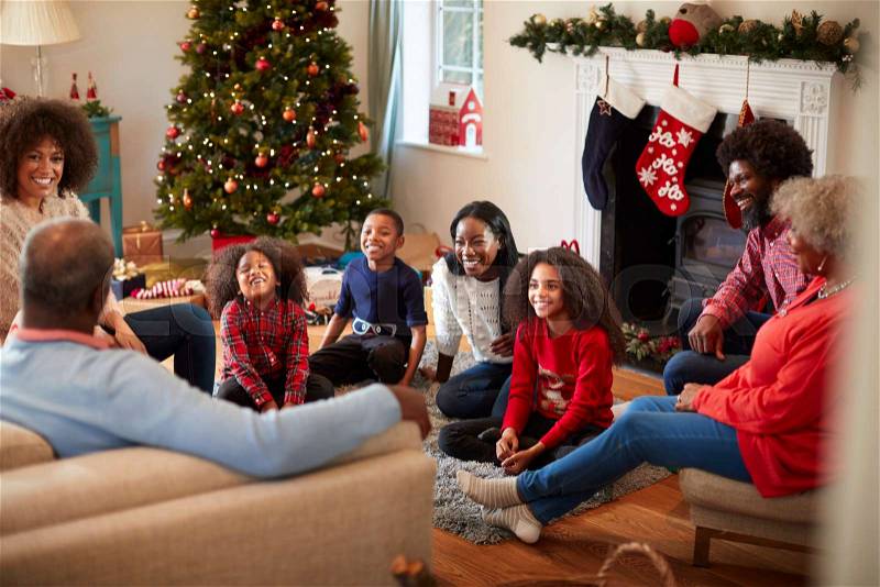 Multi Generation Family Sitting In Lounge At Home On Christmas Day, stock photo