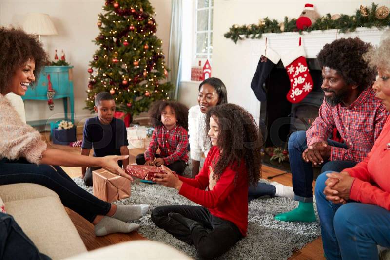 Daughter Giving Mother Gift As Multi Generation Family Celebrate Christmas At Home Together, stock photo
