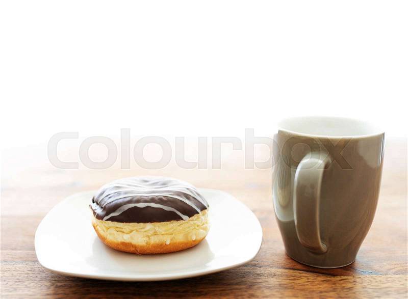 Jelly doughnut and coffee cup on wooden table, stock photo