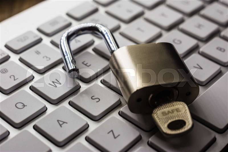 Open padlock with word SAFE on key on white pearl keyboard, dark tone with natural light reflect on objects. Cracking password, encryption, internet access, cyber ..., stock photo