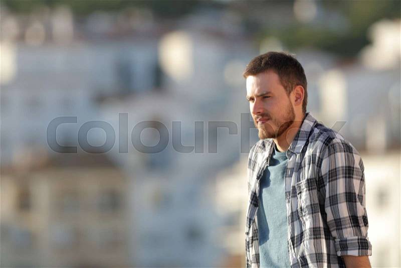 Relaxed man contemplating beautiful views in a town at sunset, stock photo