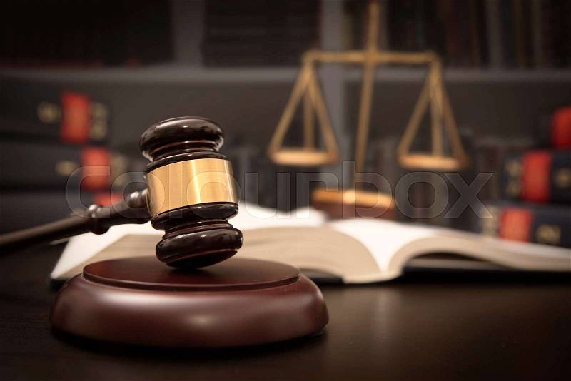 Judge gavel and scale in court. Library with lot of books in background, stock photo