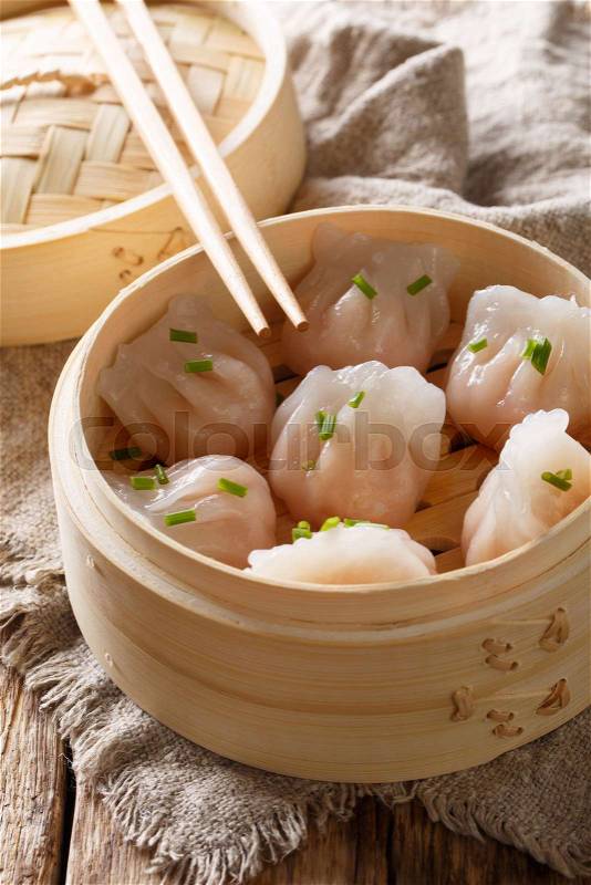 Cooked dumplings inside of bamboo steamer on the table. vertical, stock photo