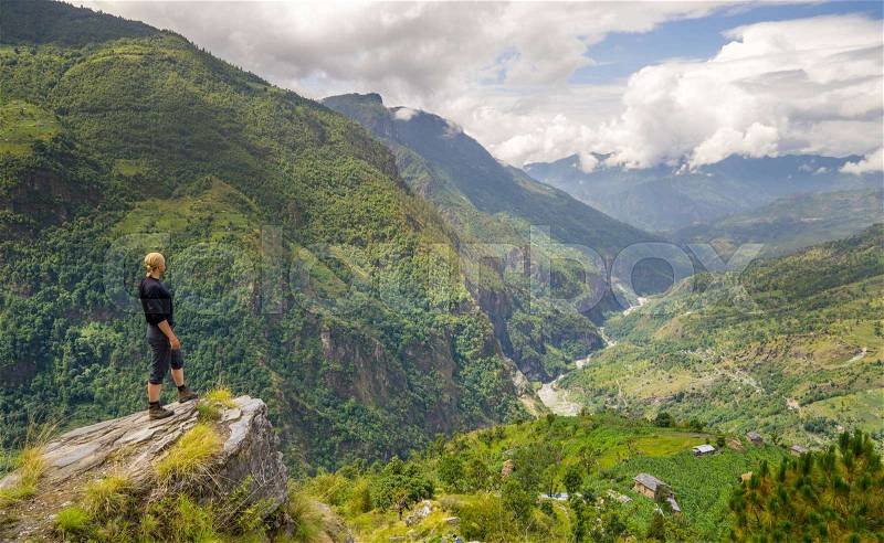 Man standing on top of the hill in Himalayas. Achievement and success. Trekking in Nepal, stock photo