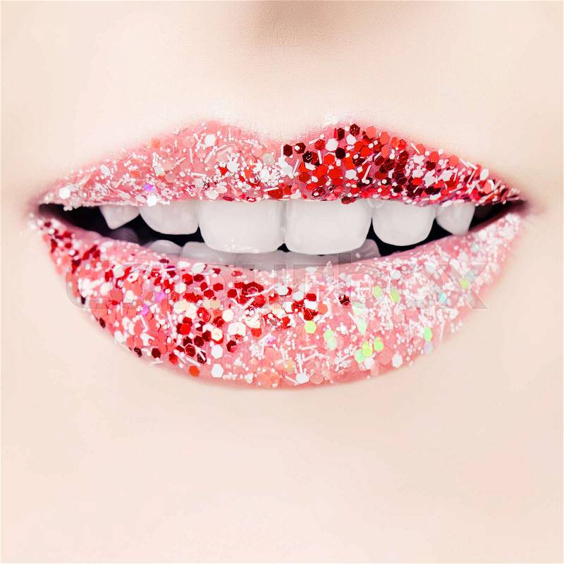 Red lips with glamorous glitter lipstick makeup closeup. Cheerful female smile with white teeth, stock photo