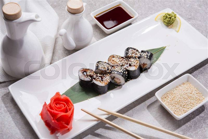 Tasty japan sushi with red ginger, soy sauce and sesame on stone table, stock photo