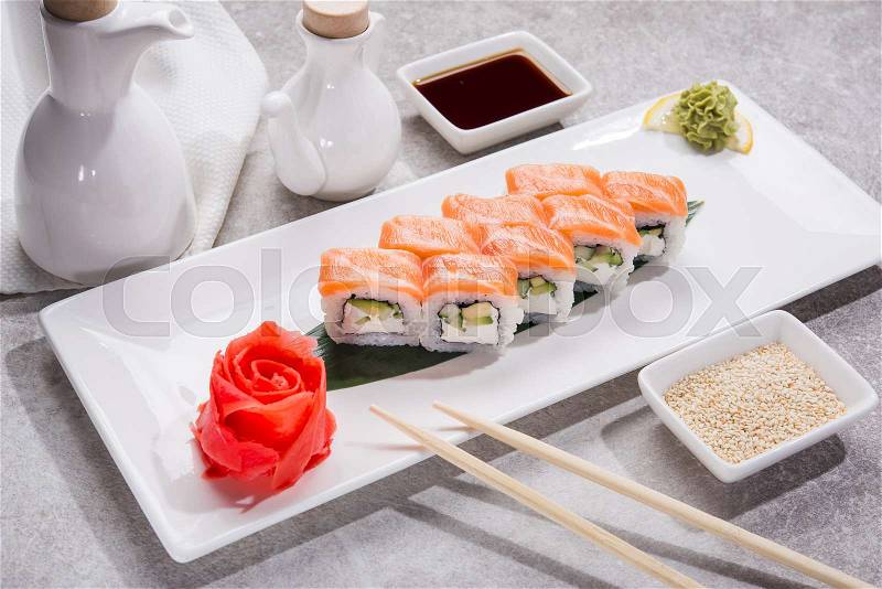 Tasty japan sushi with red ginger, soy sauce and sesame on stone table, stock photo