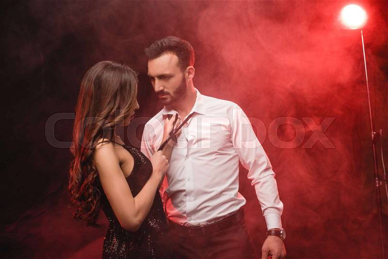 Passionate couple in red smoky room , stock photo