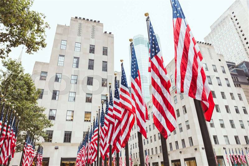 Low angle view of american flags and buildings, new york, usa, stock photo