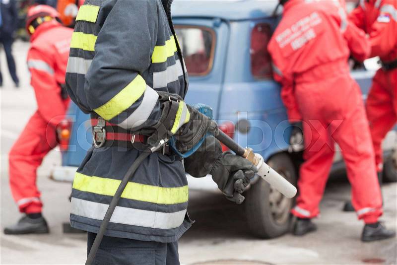 Firefighters in a rescue operation following a serious road traffic accident , stock photo