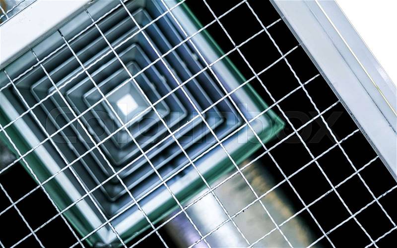 Building interior air conditioner on the ceiling with wire mesh, stock photo