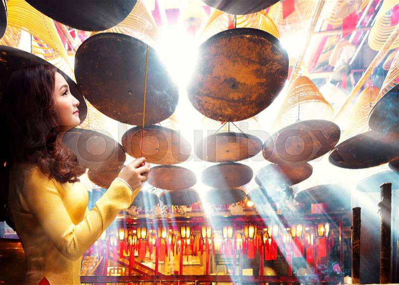 Chinese lady in gold cheongsam dress in chinese temple, Hong kong, China, stock photo