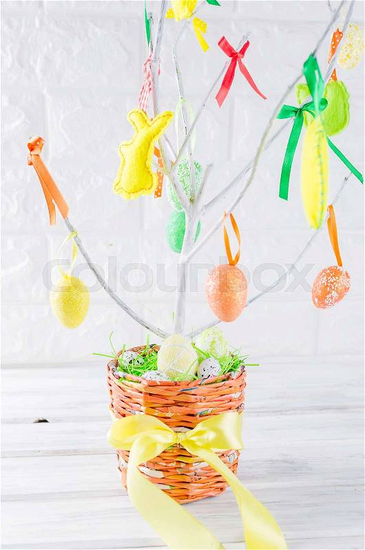 Colorful easter felt toys and eggs on tree branches in pot as easter decorations close up, holiday concept, copy space, stock photo
