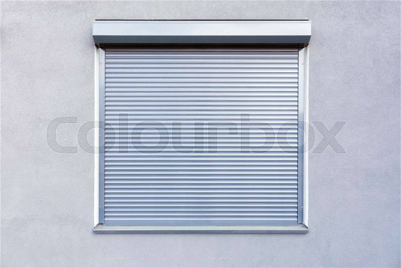 Light gray metal blinds on the windows of the facade of the house, stock photo
