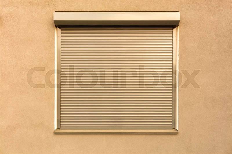 Light brown metal blinds on the window of the facade of the house, stock photo