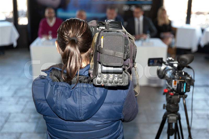 News conference. Filming an event with a video camera. Cameraman, stock photo