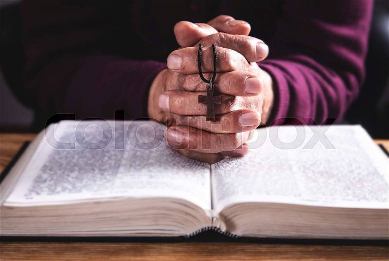 Hands of elderly woman praying. Religion concept, stock photo