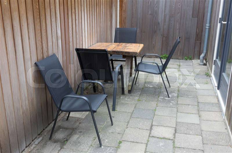 Table and chairs In small stone garden in the Netherlands, stock photo