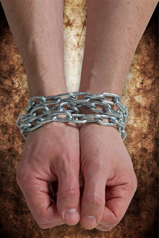 Hands chained together, stock photo